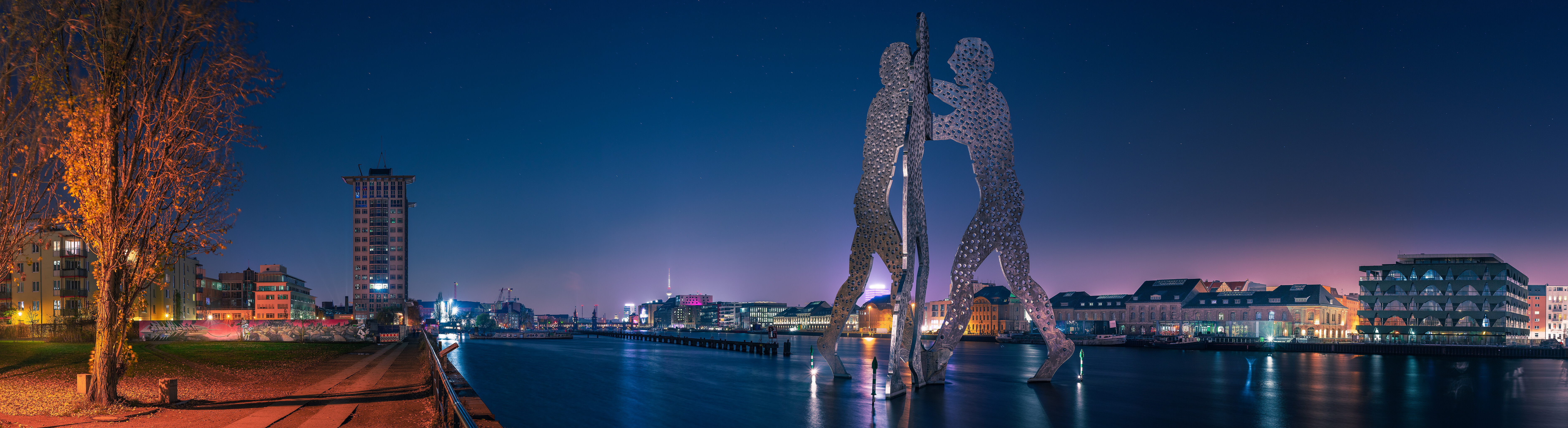Molecule Man – drei beleuchtete Figuren auf der Spree bei Nacht in Berlin