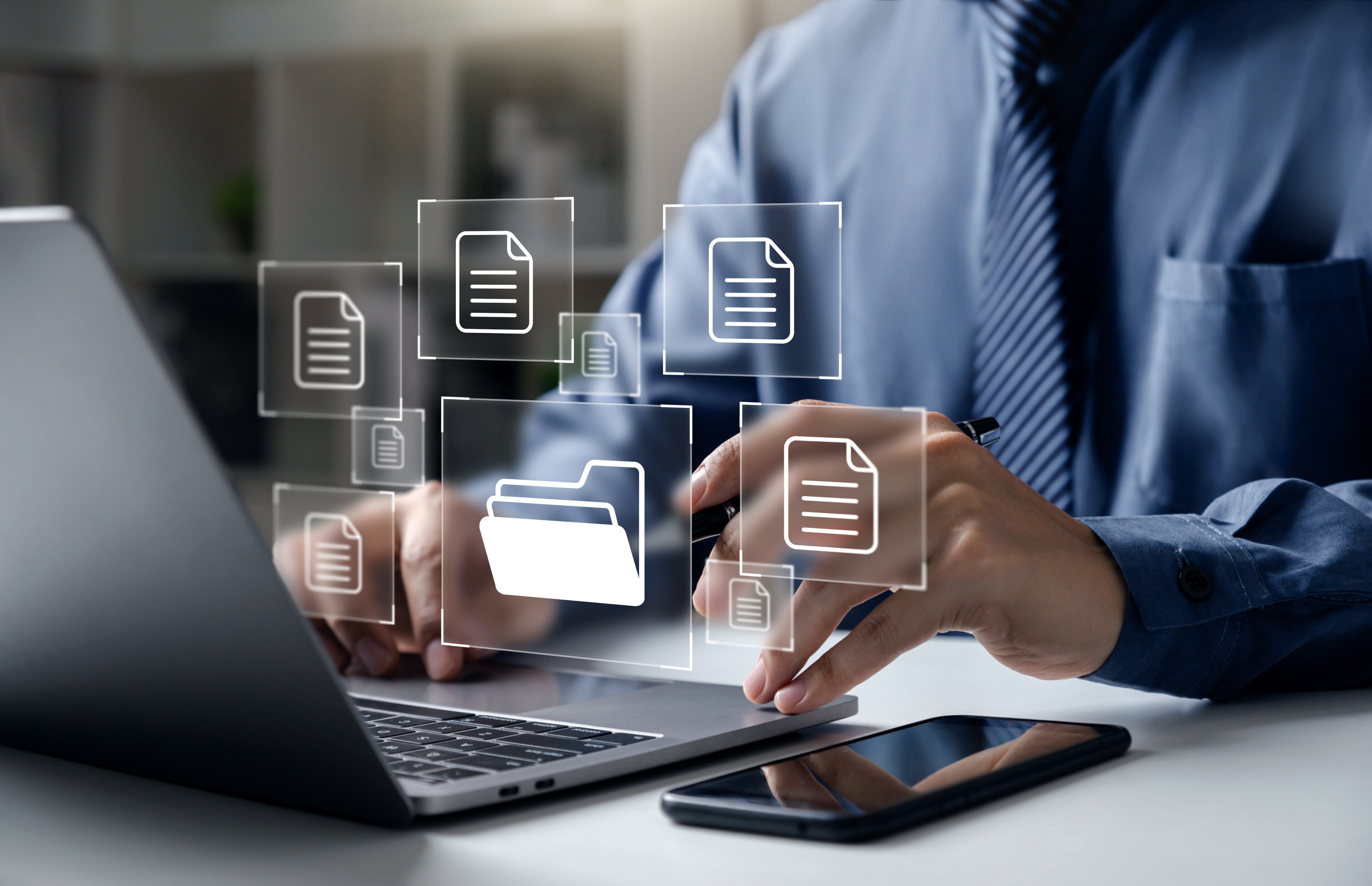 Person vor einem Notebook, mit schwebenden Symbolen von Dokumenten und Ordnern