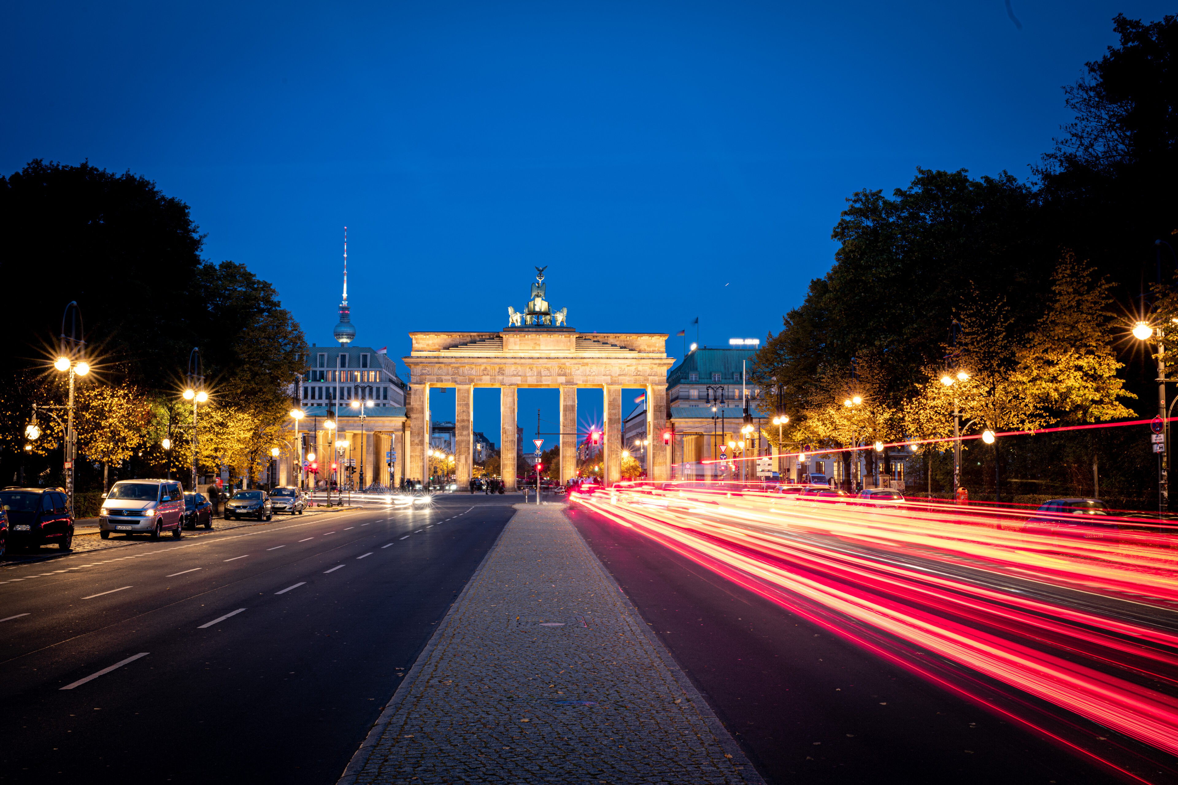 Beleuchtetes Brandenburger Tor mit Lichtspuren vorbeifahrender Autos